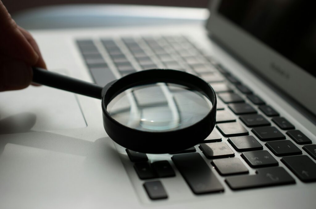 Symbolische Darstellung: Recherche zu mentaler Gesundheit im Studium mit Laptop und Lupe.